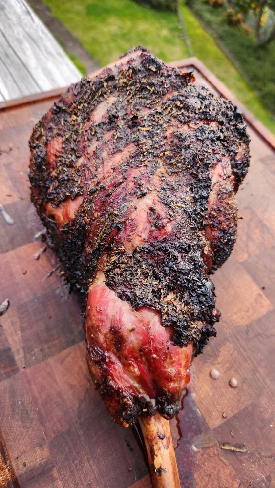 Cherry serving board beside a charcoal grill